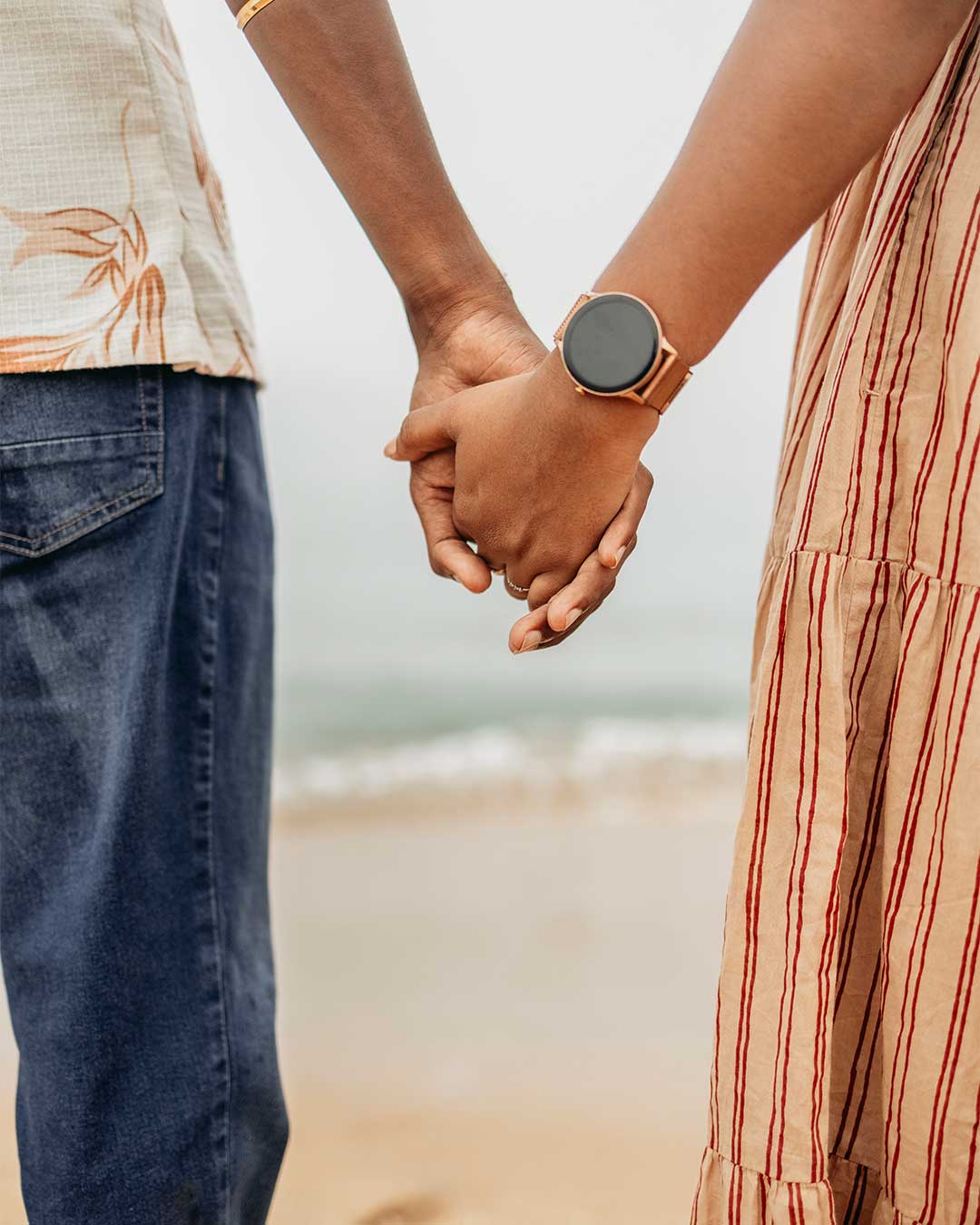 Bride and groom holding hands on the shoreline